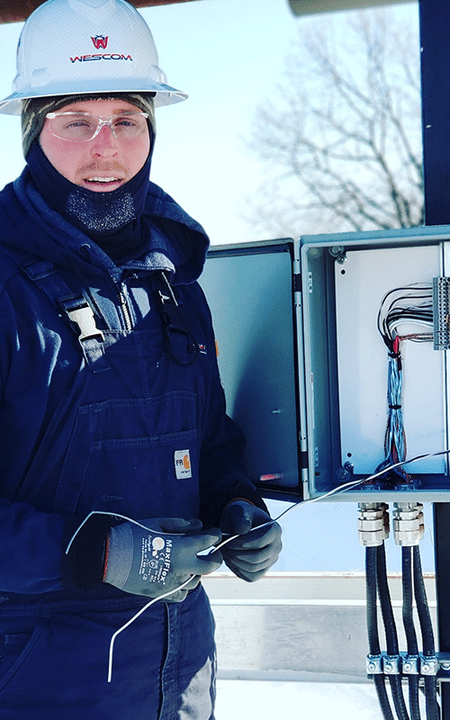 Wescom employee doing repair on electrical box