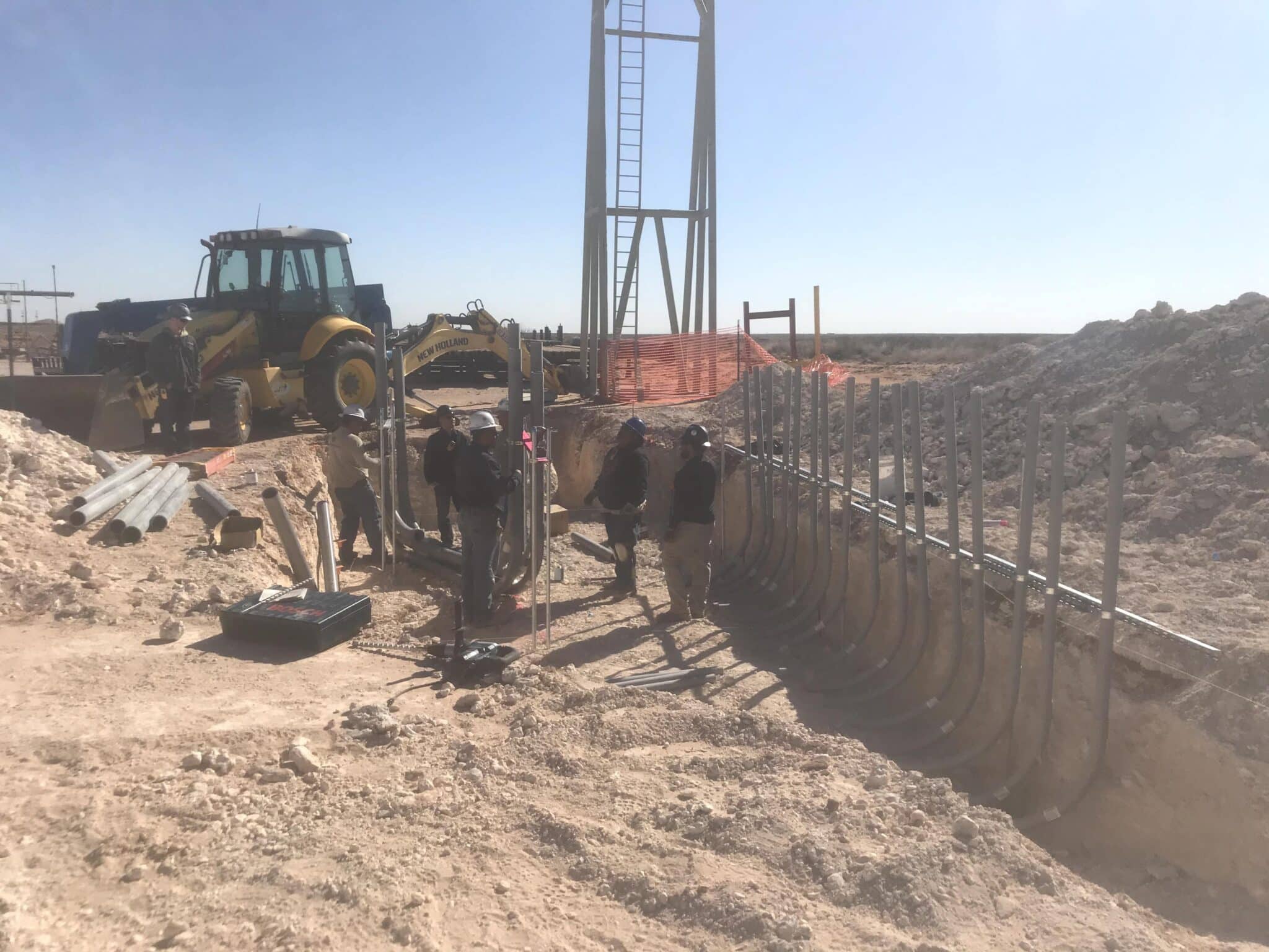 Men laying reinforced pipe in a dug out part of jobsite