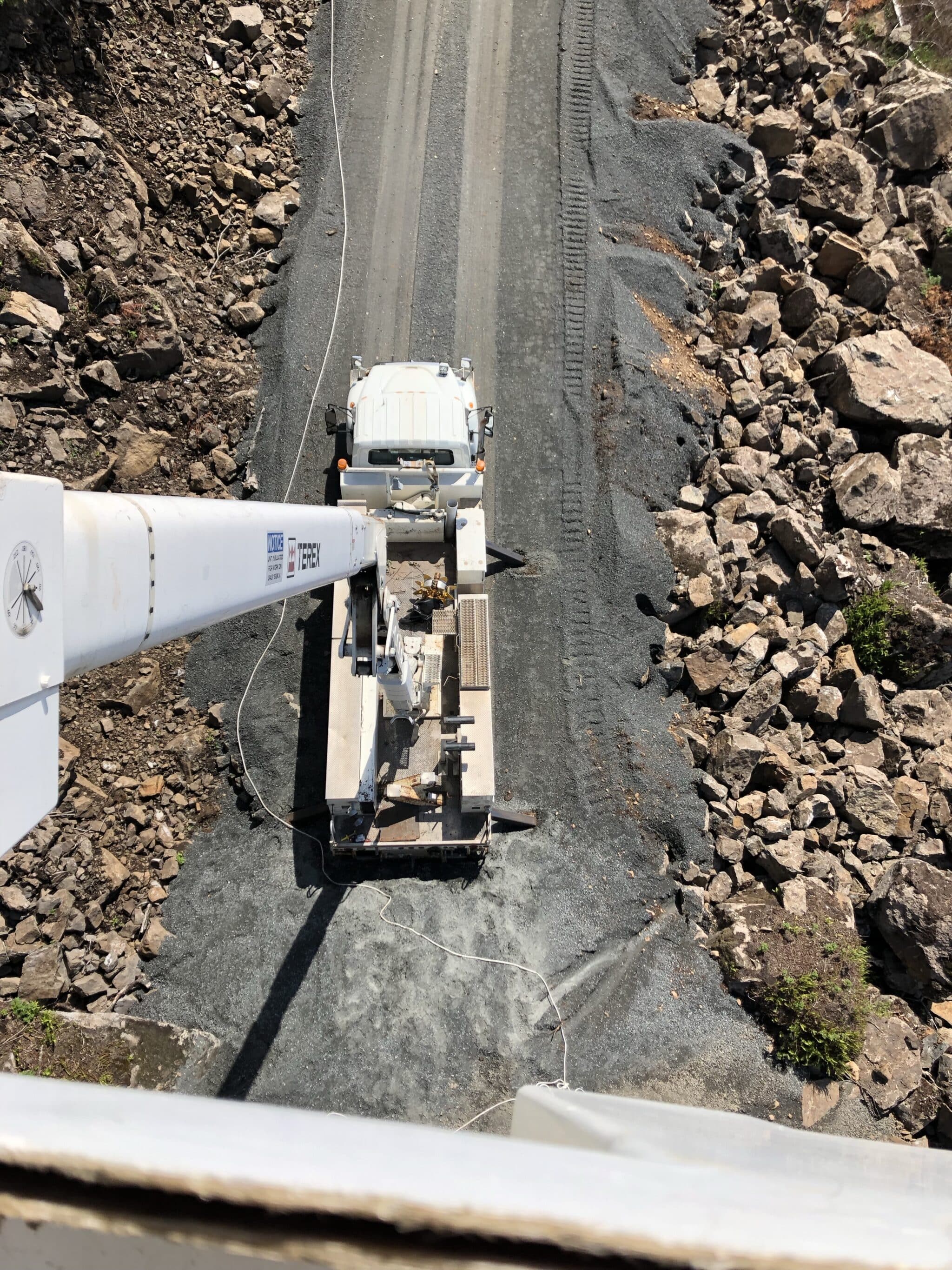 View from the top of the crane arm to the truck and ground below