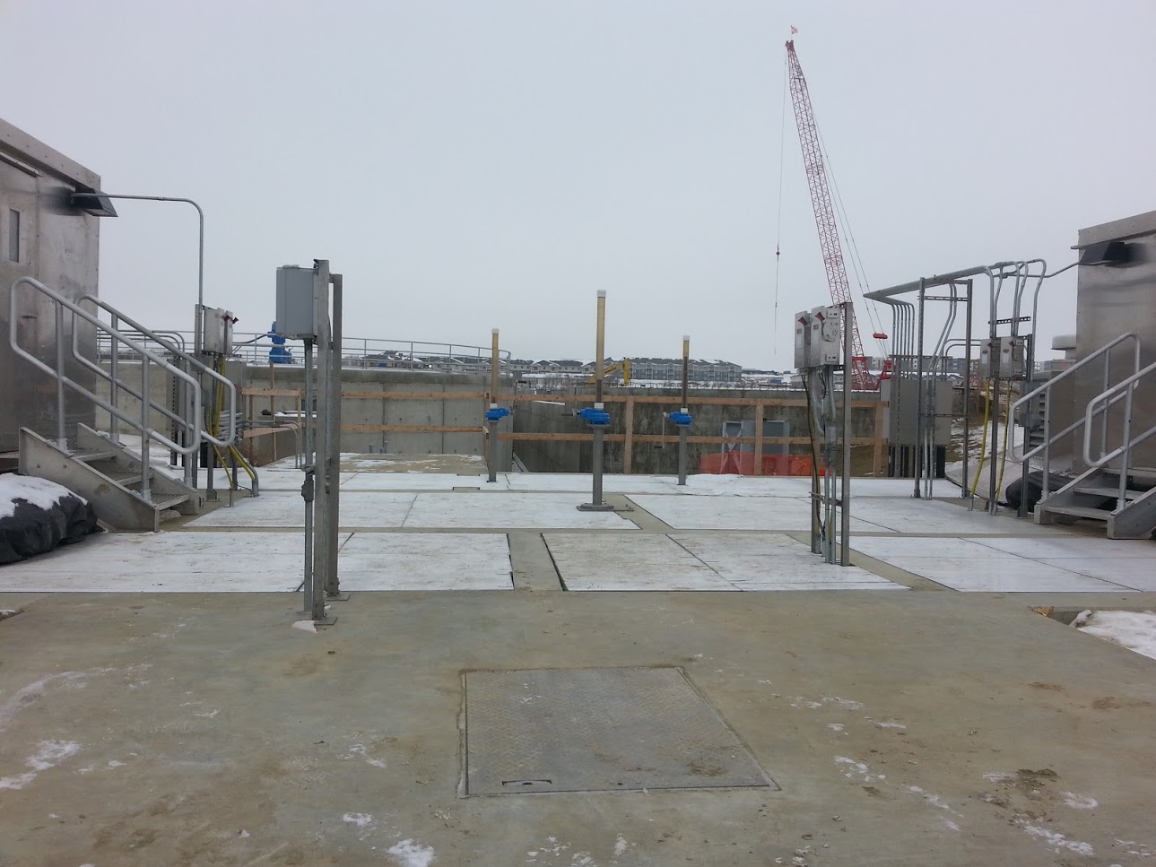 Large metal ground panels on job site with crane in background