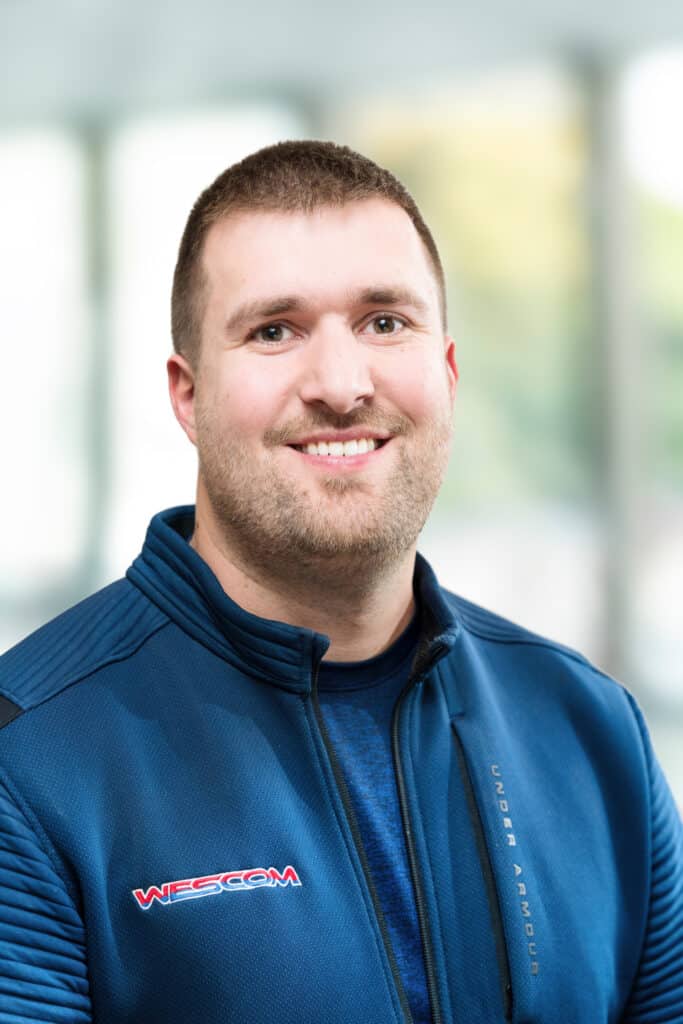 Smiling Wescom employee wearing blue shirt