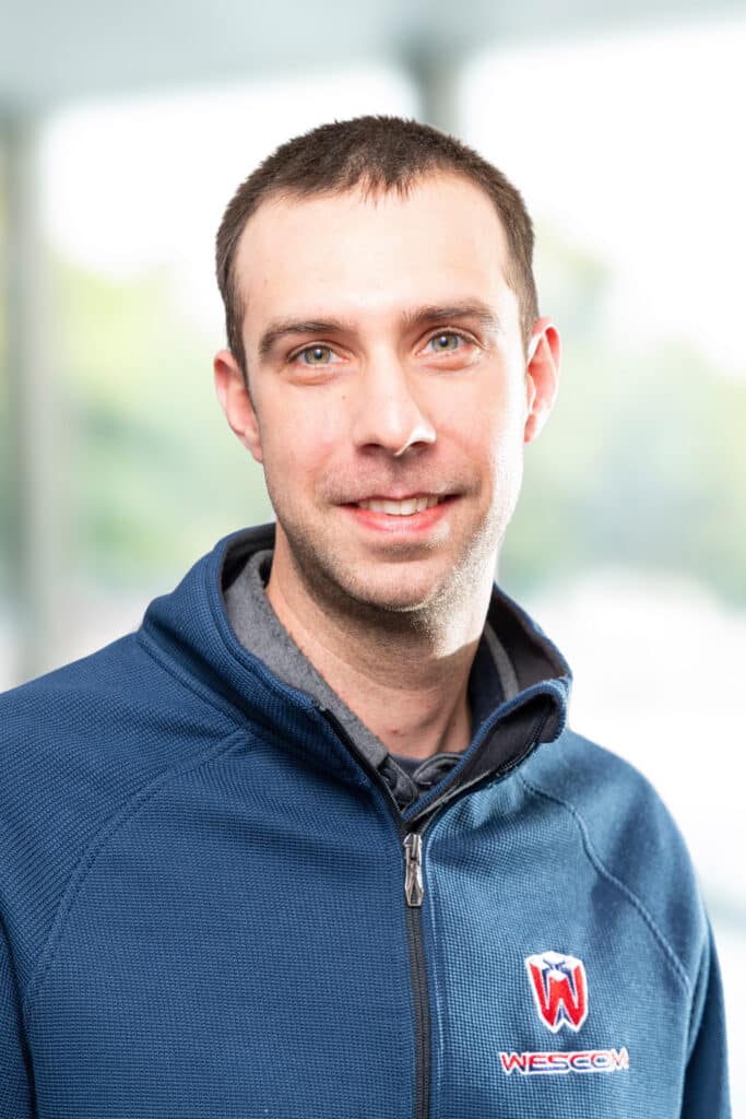 Smiling Wescom employee in blue shirt