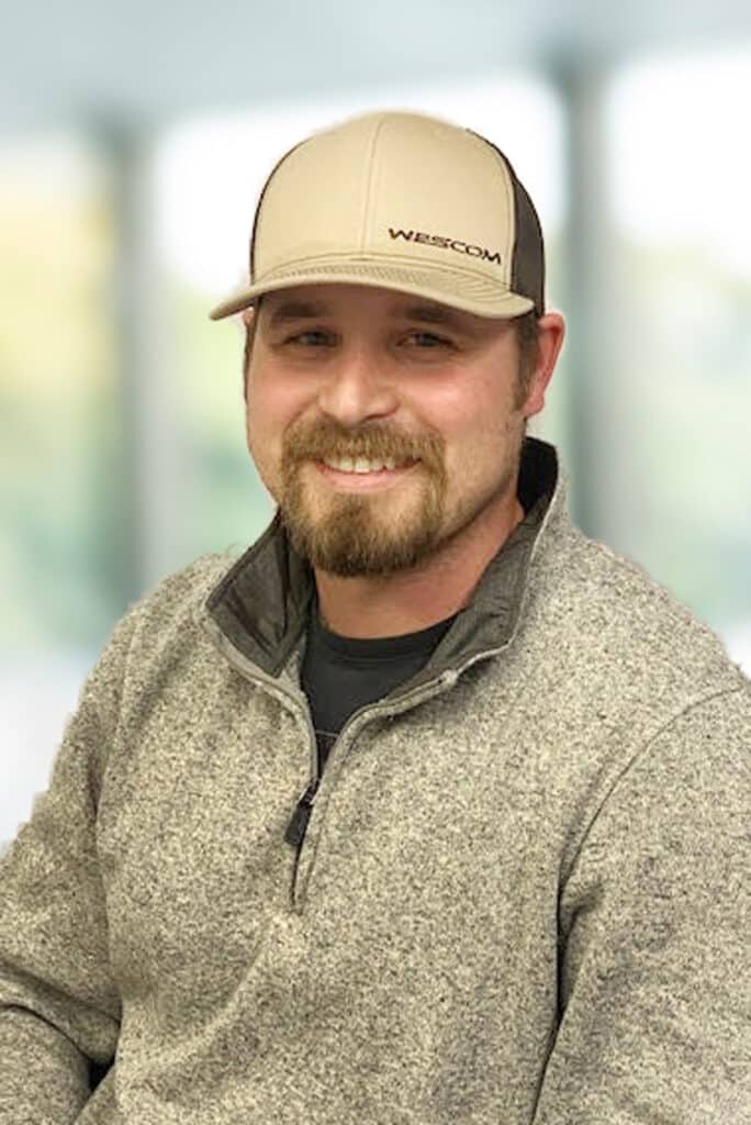 Smiling Wescom employee in gray shirt