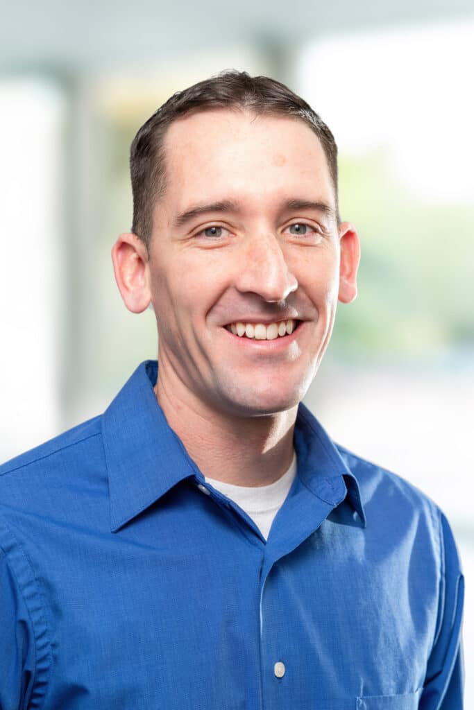 Smiling Wescom employee in blue shirt