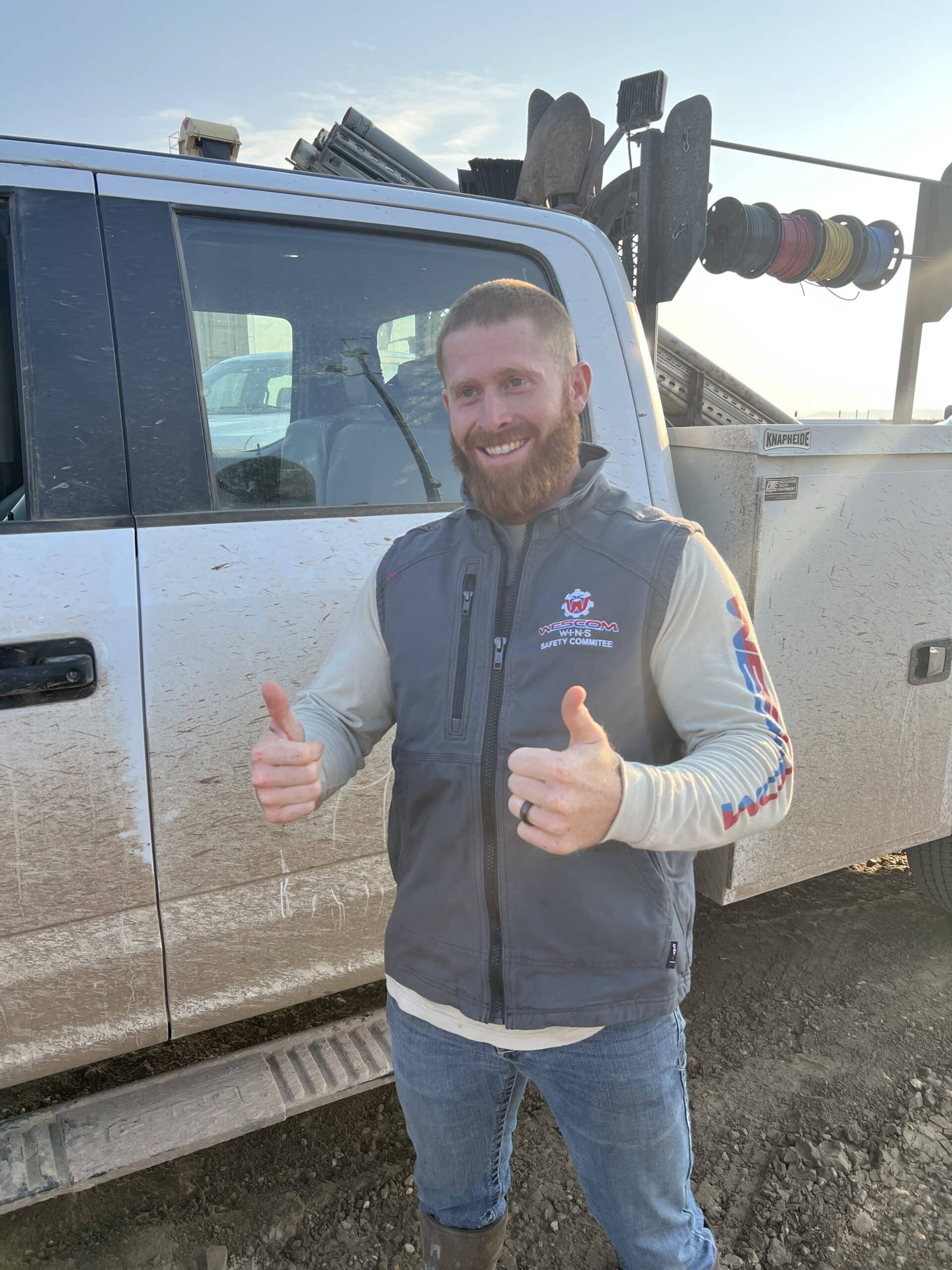 Man smiling with two thumbs up wearing a wescom vest