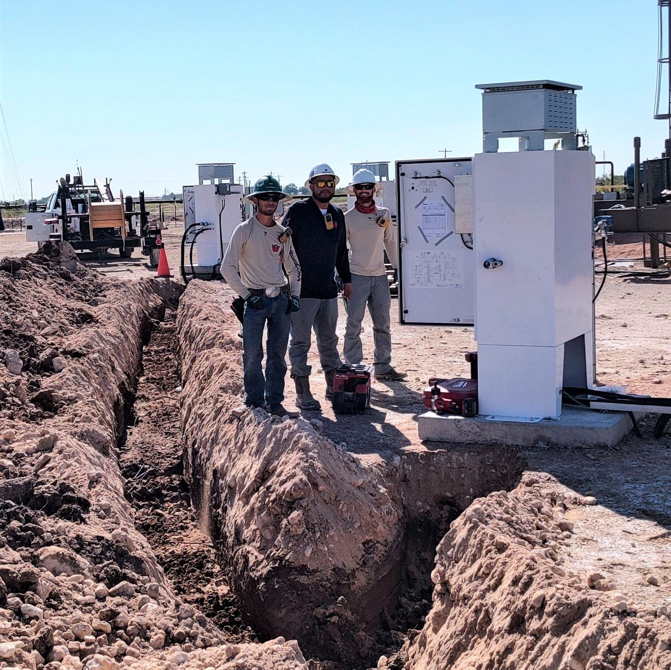 Men standing by electrical box next to wire pull at a job.
