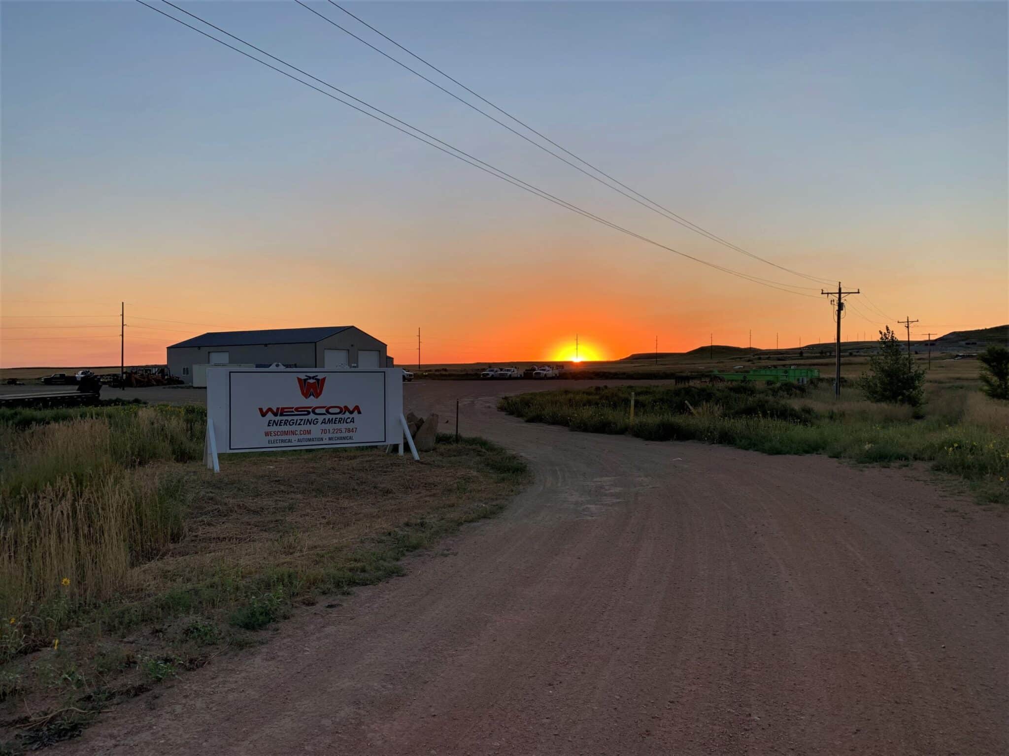 Photo of the Wescom sign and shop with the sunset in the background in North Dakota/Bakken