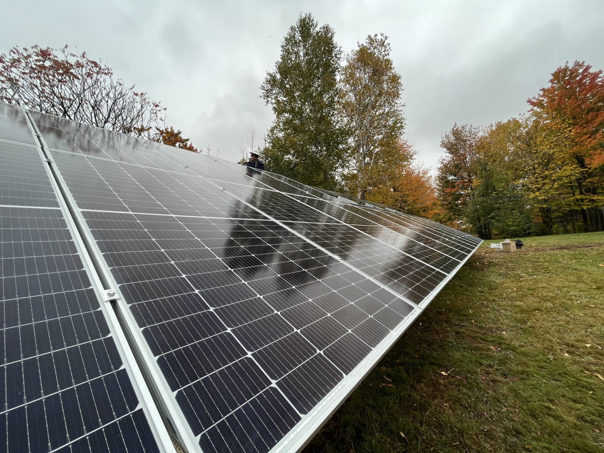 Solar Installation that has trees behind it with leaves that are falling. Pay.