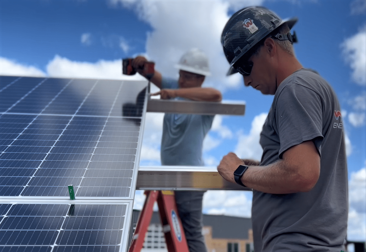 Two men working on installing a solar array at Epicurean