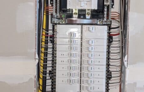 residential electrical panel with service cable and white circuit breakers